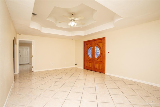 entrance foyer featuring a raised ceiling, ceiling fan, and light tile patterned flooring