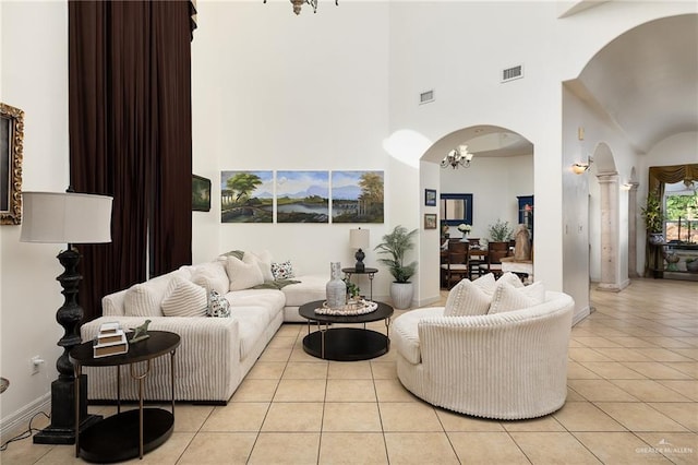 806 Beryl Cir, Weslaco, TX 78596 - living area featuring arched walkways, a chandelier, light tile patterned flooring, high vaulted ceiling, and ornate columns