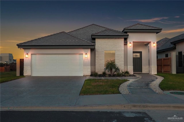 4720 Waterford Ave, Edinburg, TX 78539 - view of front of property featuring stone siding, a garage, driveway, a tile roof, and stucco siding