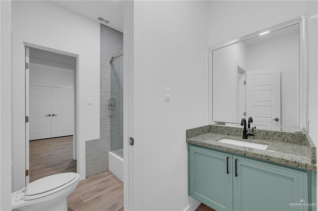 4720 Waterford Ave, Edinburg, TX 78539 - full bath with wood finished floors, vanity, toilet, and bath / shower combo with glass door
