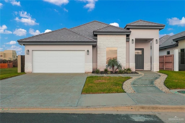4720 Waterford Ave, Edinburg, TX 78539 - view of front of property featuring stone siding, a garage, stucco siding, driveway, and a tile roof