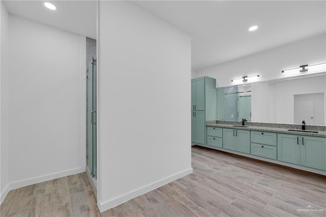 4720 Waterford Ave, Edinburg, TX 78539 - full bath with double vanity, a stall shower, wood finished floors, recessed lighting, and baseboards