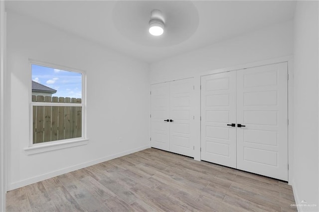 4720 Waterford Ave, Edinburg, TX 78539 - unfurnished bedroom with two closets, wood finished floors, ceiling fan, and baseboards