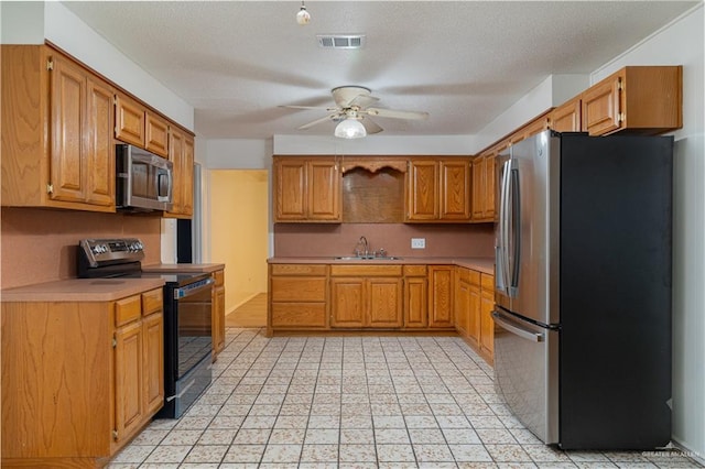 kitchen with visible vents, a sink, light countertops, appliances with stainless steel finishes, and a ceiling fan