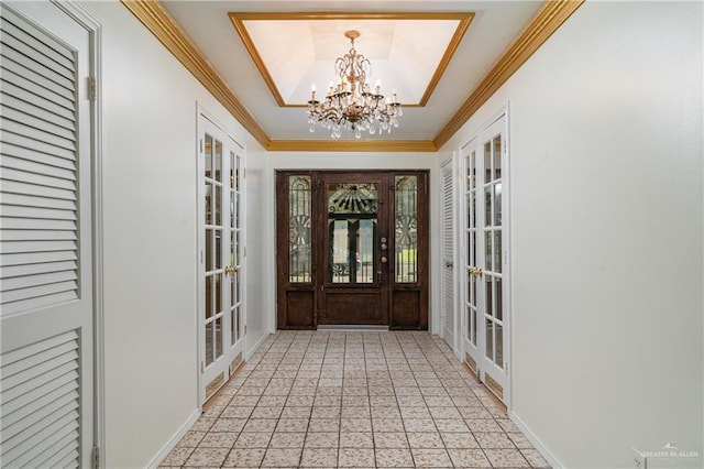 foyer featuring a chandelier, crown molding, french doors, and a tray ceiling