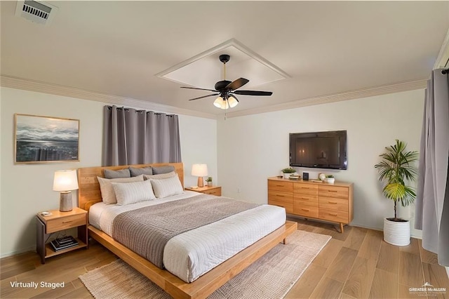 bedroom with visible vents, baseboards, a ceiling fan, light wood-style floors, and crown molding