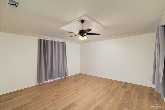 spare room with ornamental molding, visible vents, and light wood-type flooring