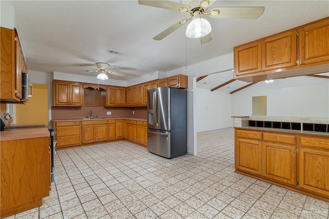 kitchen with light floors, visible vents, brown cabinets, ceiling fan, and appliances with stainless steel finishes