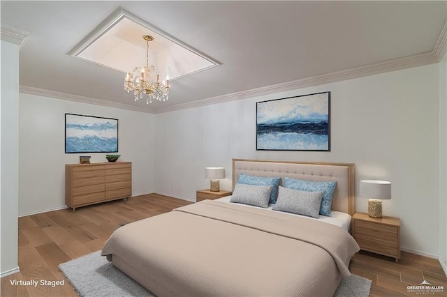 bedroom featuring crown molding, wood finished floors, an inviting chandelier, and baseboards
