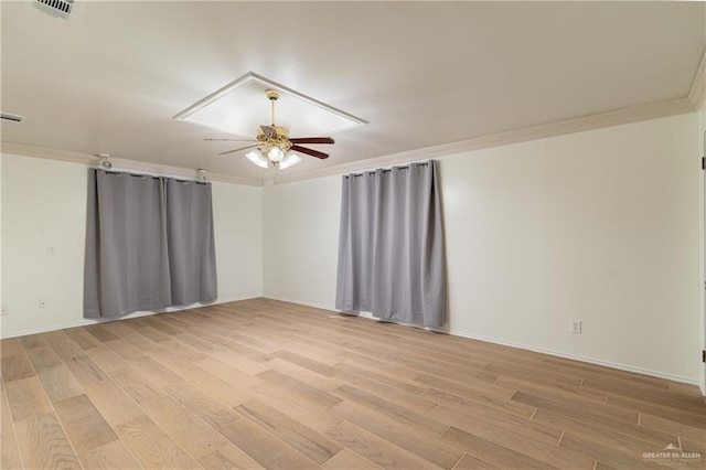 unfurnished room with light wood-style floors, visible vents, crown molding, and ceiling fan