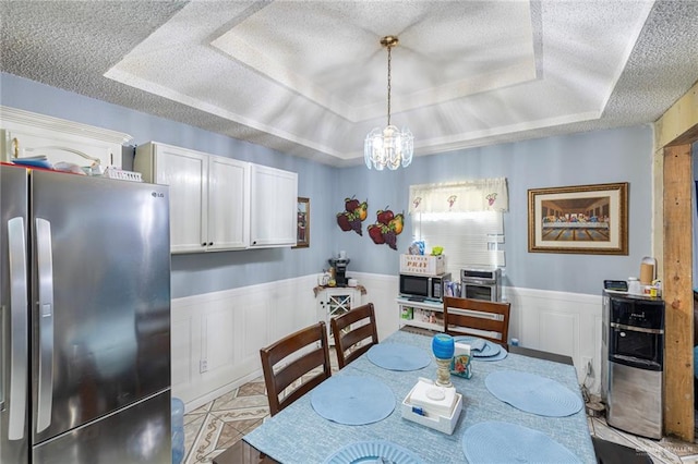 510 S 9th St, Hidalgo, TX 78557 - dining area with a raised ceiling, a chandelier, a textured ceiling, and a wainscoted wall