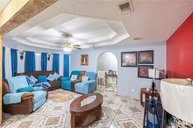 510 S 9th St, Hidalgo, TX 78557 - living area with a textured ceiling, a tray ceiling, ceiling fan, light tile patterned floors, and arched walkways