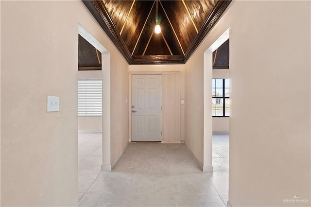 hallway featuring crown molding, wooden ceiling, and vaulted ceiling