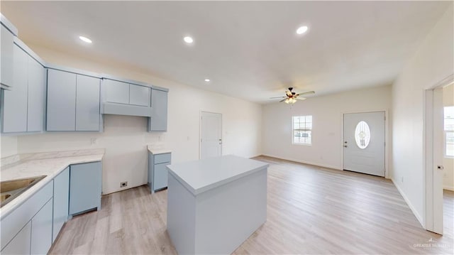 kitchen featuring light hardwood / wood-style flooring, a kitchen island, and ceiling fan