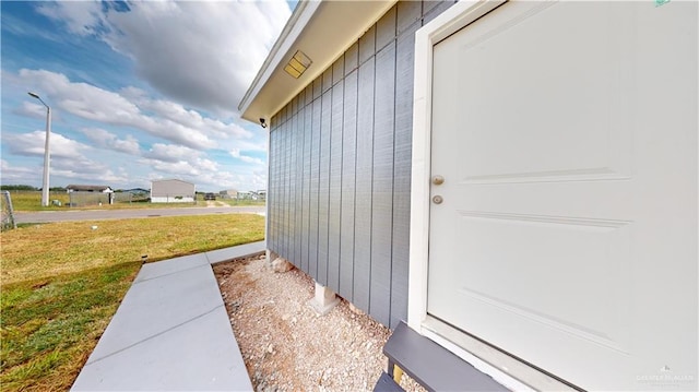 entrance to property featuring a lawn