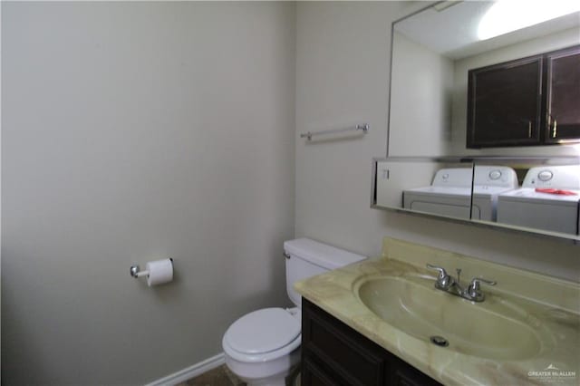 bathroom featuring washer and dryer, toilet, and vanity