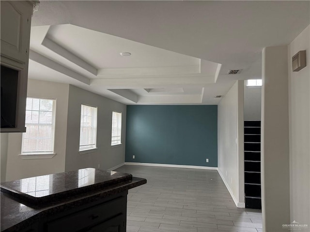 spare room with light wood-type flooring and a tray ceiling