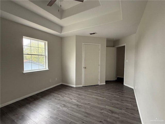 unfurnished room with a tray ceiling, ceiling fan, and hardwood / wood-style floors