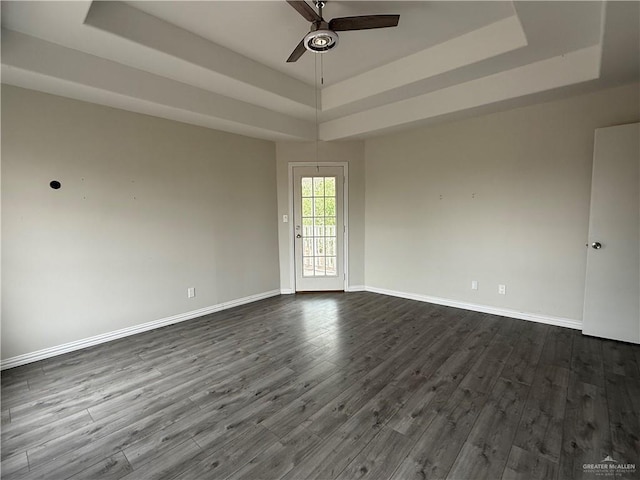 unfurnished room featuring hardwood / wood-style flooring, ceiling fan, and a tray ceiling