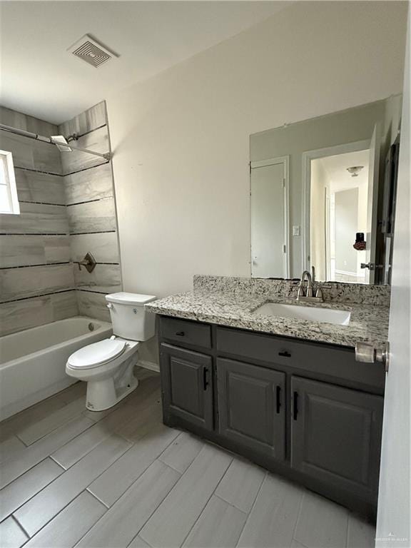 full bathroom with vanity, toilet, and tiled shower / bath combo