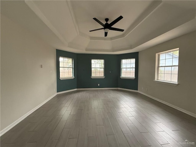 unfurnished room with hardwood / wood-style flooring, ceiling fan, and a tray ceiling