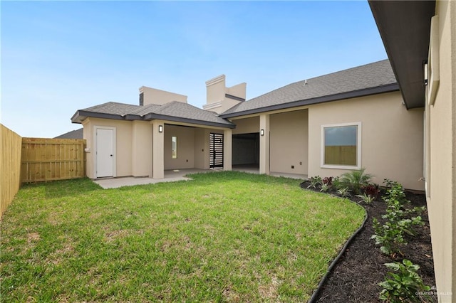 back of house with fence private yard, a patio area, stucco siding, and a yard