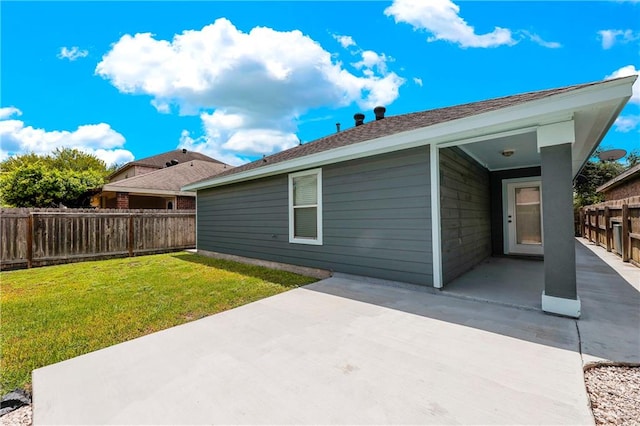 back of property with a yard and a patio