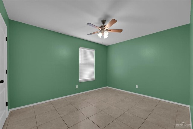 spare room with ceiling fan and light tile patterned floors