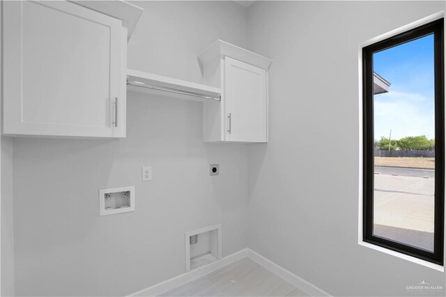 clothes washing area with hookup for a washing machine, cabinet space, baseboards, and electric dryer hookup