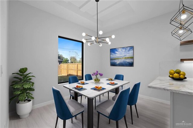 dining room with an inviting chandelier, light wood-style floors, and baseboards