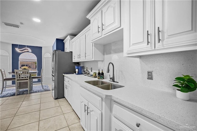 317 Ohara Dr, Pharr, TX 78577 - kitchen with a sink, light tile patterned flooring, white cabinets, freestanding refrigerator, and backsplash
