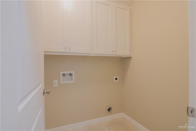 washroom with hookup for an electric dryer, hookup for a washing machine, and cabinets