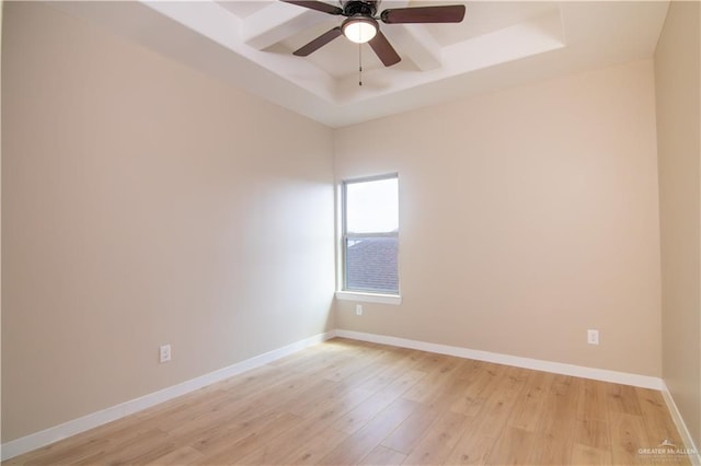 unfurnished room featuring ceiling fan, a tray ceiling, and light hardwood / wood-style flooring