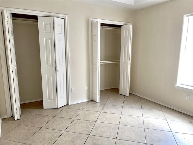 unfurnished bedroom with light tile patterned floors and multiple windows