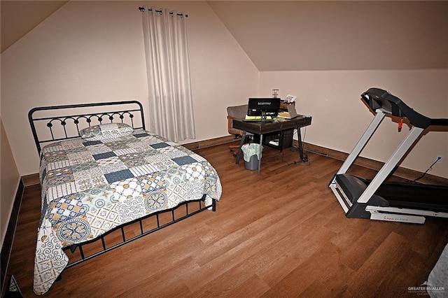 bedroom featuring wood-type flooring and vaulted ceiling