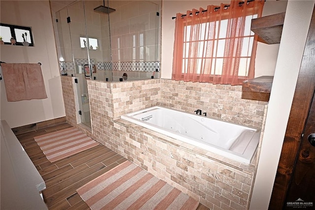 bathroom with hardwood / wood-style flooring and shower with separate bathtub