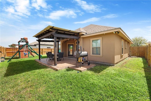 back of house featuring a fenced backyard, a patio, a playground, and stucco siding