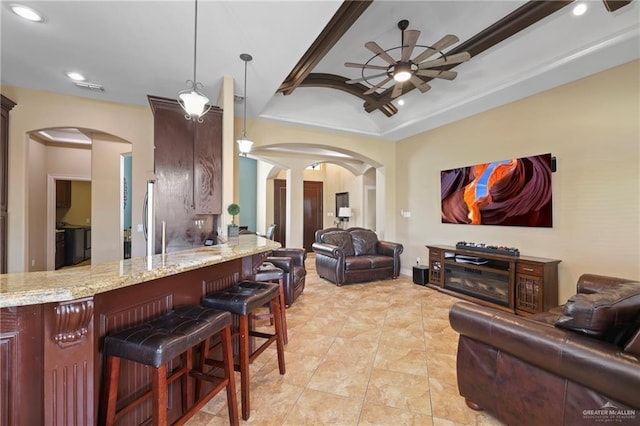 living area featuring arched walkways, ceiling fan, and recessed lighting