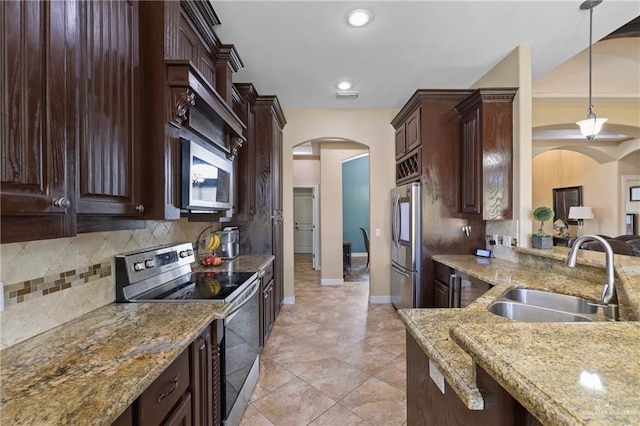 kitchen with arched walkways, stainless steel appliances, visible vents, a sink, and dark brown cabinets