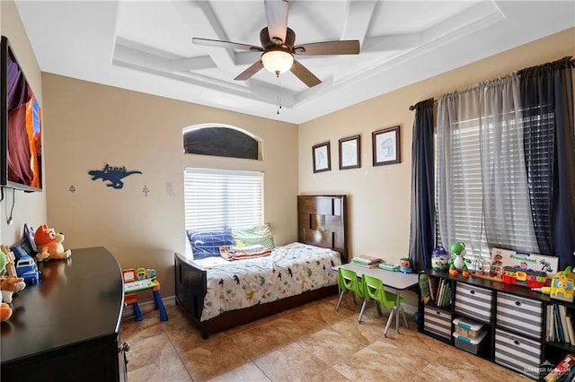 bedroom featuring a tray ceiling, ceiling fan, and baseboards