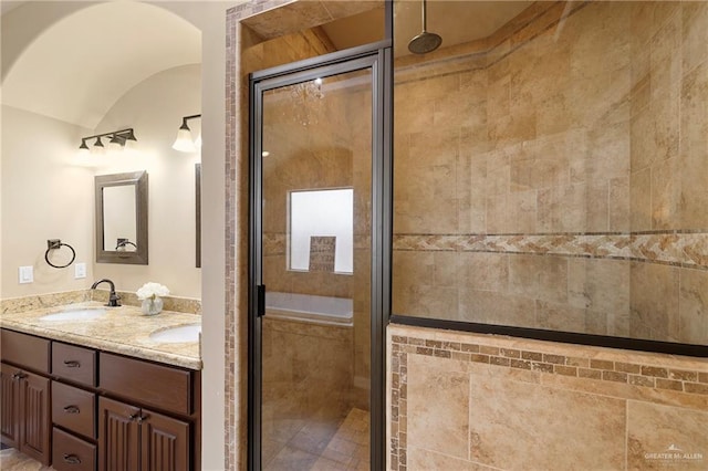 bathroom with lofted ceiling, double vanity, a sink, and a shower stall