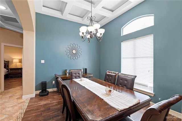 dining area with baseboards, a chandelier, coffered ceiling, and wood finished floors