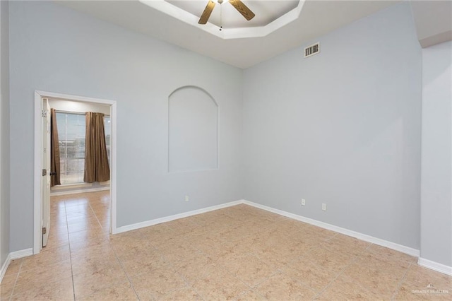 unfurnished room featuring a raised ceiling and ceiling fan