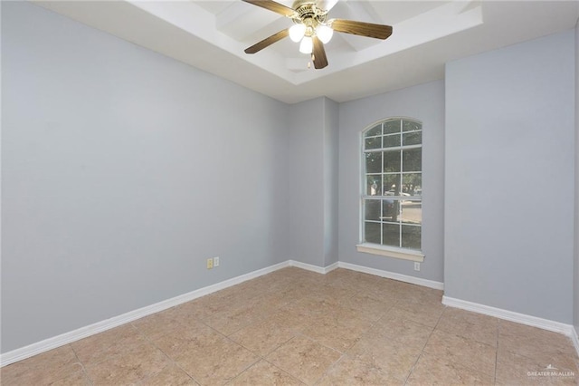 spare room with a raised ceiling and ceiling fan