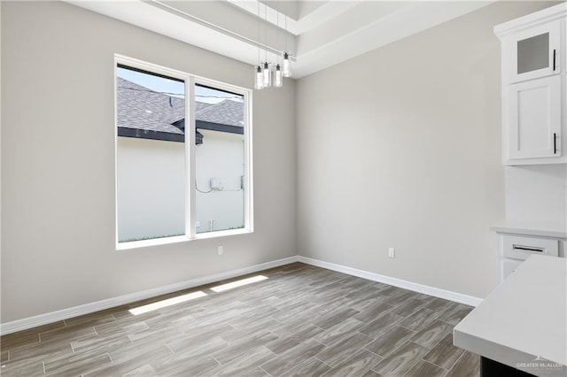 unfurnished dining area with light wood-type flooring and a chandelier