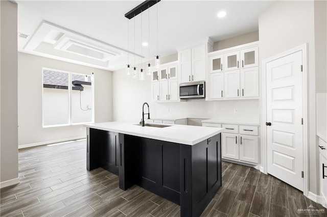 kitchen featuring white cabinetry, a kitchen island with sink, sink, and dark wood-type flooring