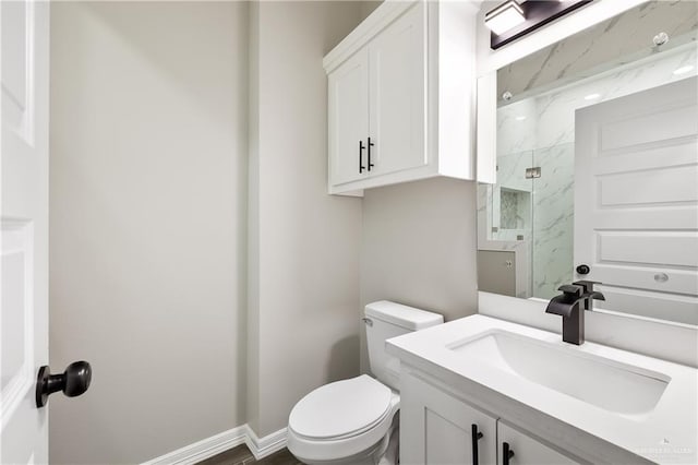 bathroom featuring vanity, toilet, and walk in shower