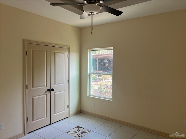 unfurnished bedroom featuring light tile patterned floors, a closet, and ceiling fan