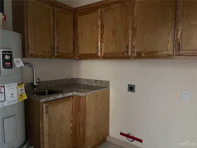 laundry room with electric dryer hookup, cabinets, sink, and water heater