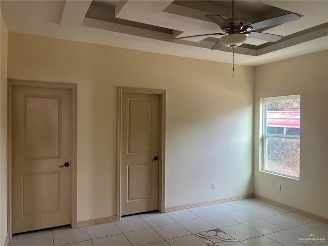 empty room with ceiling fan and light tile patterned floors